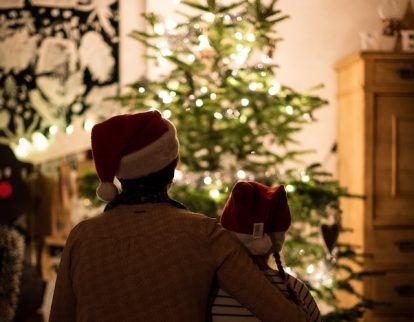 Couple sitting in front of a Christmas tree